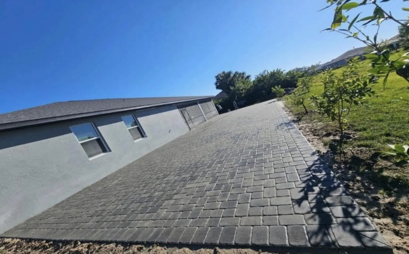 Wide gray paver area alongside a Florida home